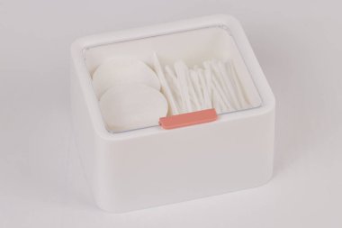 Beyaz arka planda izole edilmiş pamuk çubukları ve pedlerle dolu kozmetik ürünleri için beyaz yeni plastik düzenleyici