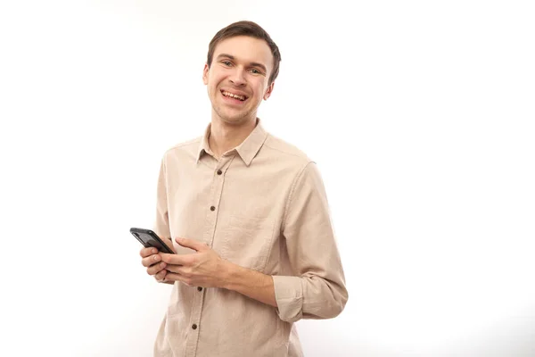 年轻英俊的高加索男子的画像 使用手机 在白色的工作室背景下 面带微笑 快乐的表情 — 图库照片