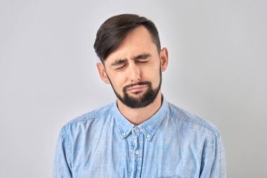 Beyaz stüdyo arka planında izole edilmiş üzgün esmer bir genç adam portresi. Hata yaptım, üzgün ve depresif.