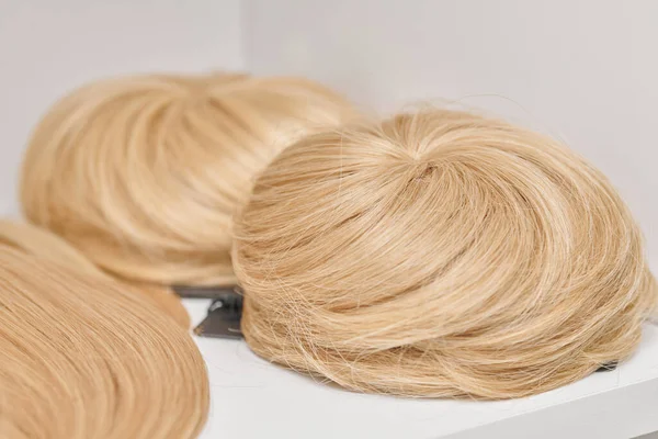 在美容美发沙龙里展示自然造型的假发的金黄色 在假发店的货架上为男人和女人留着各种不同的短发 — 图库照片