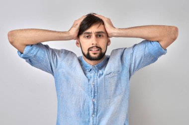 Kafasını beyaz stüdyo arka planında soyutlamış üzgün esmer bir genç adam portresi. Hata yaptım, üzgün ve depresif.