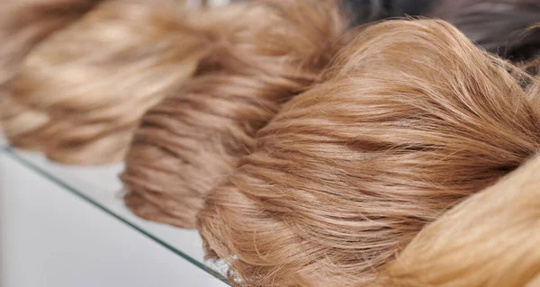 在美容美发沙龙里展示自然造型的假发的金黄色 在假发店的货架上为男人和女人留着各种不同的短发 — 图库照片