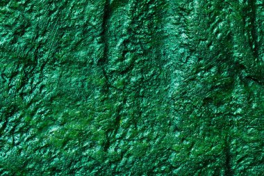 Dekoratif yeşil macun arka planı. Spatula ile doldurulmuş duvar dokusu, alçı üzerine kaotik çizgiler ve darbeler. Yaratıcı tasarım, taş desen, cemen