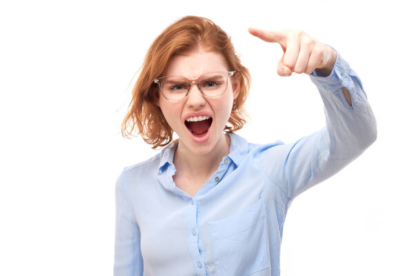 Portrait angry redhead young woman screaming isolated on white studio background, showing negative emotion