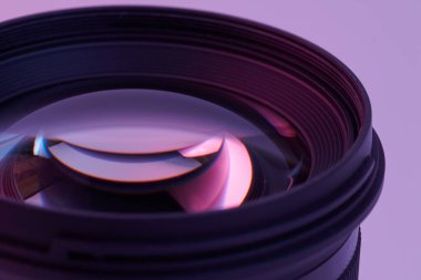Kamera merceği, beyaz arkaplanda pembe neon ışıkta izole edilmiş.