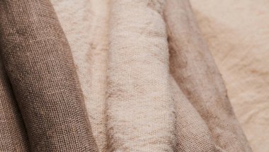 Farklı dokularda ve renklerde çarşaf. Doğal kumaşlar organik keten ve rulo içinde pamuk, el yapımı tekstil. Eko, kırsal, boho, hygge dekoru için çuval bezi ve tuval.
