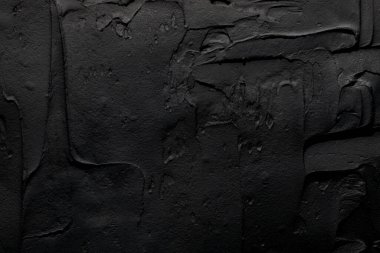 Dekoratif siyah macun arka planı. Spatula ile doldurulmuş duvar dokusu, alçı üzerine kaotik çizgiler ve darbeler. Yaratıcı tasarım, taş deseni, çimento