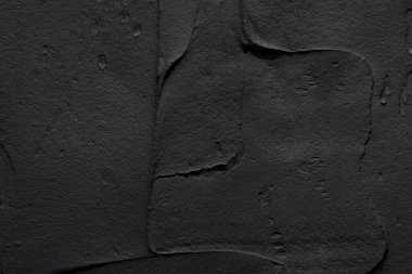 Dekoratif siyah macun arka planı. Spatula ile doldurulmuş duvar dokusu, alçı üzerine kaotik çizgiler ve darbeler. Yaratıcı tasarım, taş deseni, çimento