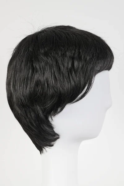 白いマネキンの頭部の自然な一見黒いウィッグ 白い背景に隔離された金属ウィッグホルダー上の短い男性または女性の髪 サイドビュー — ストック写真