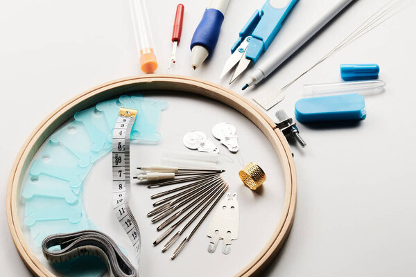 Set of items for needlework, cross stitching and embroidery isolated on white background, hoop, needles, canvas