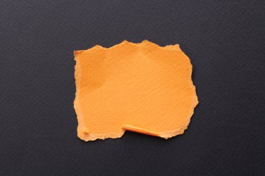 Yırtık kenarlı kağıt parçalarından sanat kolajı. Yapışkan notlar turuncu siyah renkler topluyor, defter sayfalarının parçalarını. Soyut arka gruplandırma