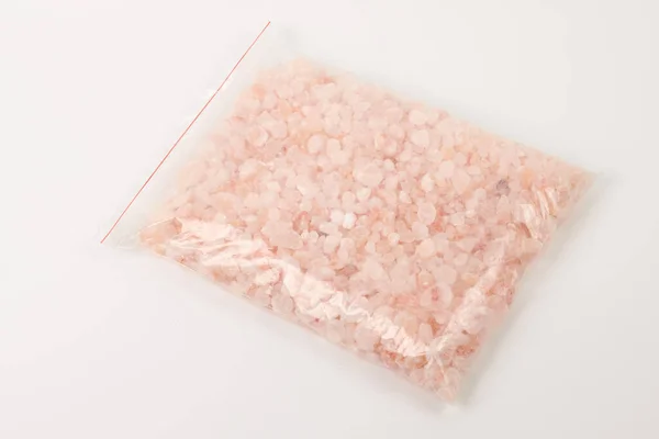 ホワイトバックに隔離されたジップバッグのチップヒマラヤピンク塩の石 — ストック写真