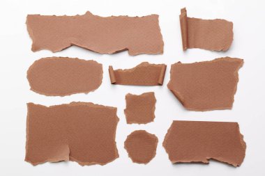 Yırtık kenarlı kağıt parçalarından sanat kolajı. Yapışkan notlar kahverengi renkler, defter sayfalarının parçalarını topluyor. Soyut arka gruplandırma