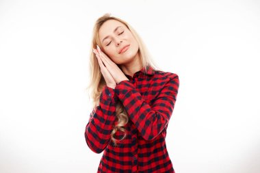 Stüdyo portresi genç sarışın kadın avuçlarını kafasının altına koydu.