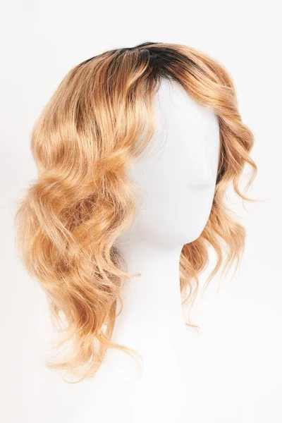 天然的金发碧眼的假发戴在白色的人体模特头上 用白色背衬把塑料假发架剪成中等长度的头发 — 图库照片