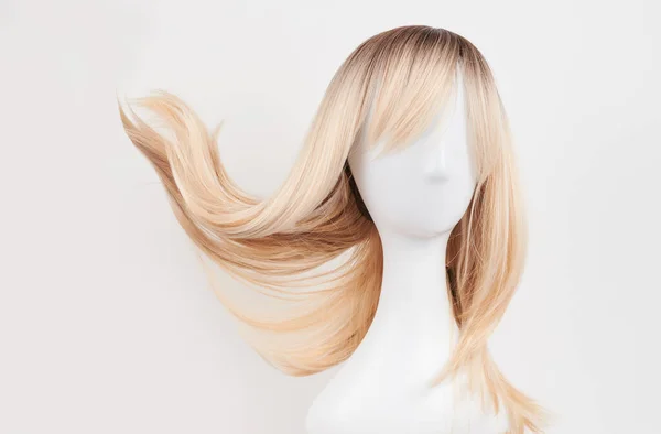 自然的金发碧眼的假发戴在白色的模特头上 塑料假发架上的长发与白色背景隔离 正面竞争 — 图库照片