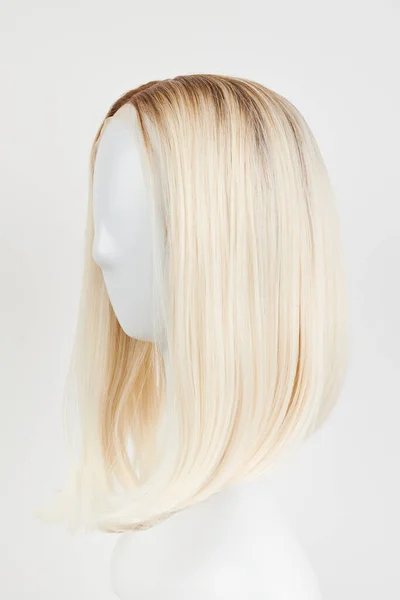 天然的金发碧眼的假发戴在白色的人体模特头上 在白色背景下隔离的塑料假发架上剪下中等长度的头发 侧面竞争 — 图库照片