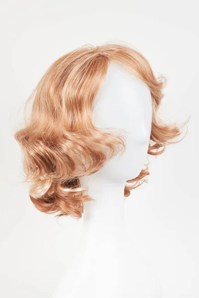 天然的金发碧眼的假发戴在白色的人体模特头上 在白色背衬上隔离的塑料假发架上剪短头发 — 图库照片
