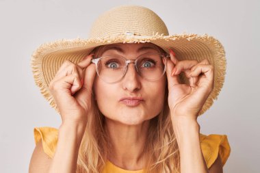 Beyaz stüdyo arka planında izole edilmiş gözlüklü 50 yaşında bir kadının portresi. Görüş kontrolü ve görüş kaybı, arama konsepti, gözlük sho