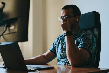 Çeşitli ofislerde bilgisayar üzerinde çalışan profesyonel bir programcı portresi. Modern bilişim teknolojileri, yapay zekanın geliştirilmesi, programlar, uygulamalar ve video oyunları konsepti
