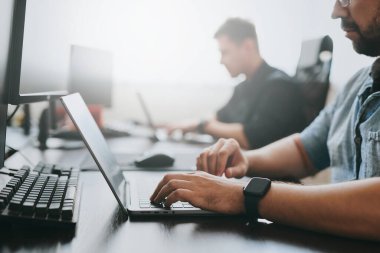 Çeşitli ofislerde bilgisayar üzerinde çalışan iki profesyonel erkek programcının portresi. Modern bilişim teknolojileri, yapay zekanın geliştirilmesi, programlar, uygulamalar ve video oyunları konsepti