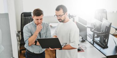 Çeşitli ofislerde bilgisayar üzerinde çalışan iki profesyonel erkek programcının portresi. Modern bilişim teknolojileri, yapay zekanın geliştirilmesi, programlar, uygulamalar ve video oyunları konsepti