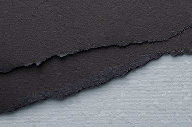 Yırtık kenarlı kağıt parçalarından sanat kolajı. Yapışkan notlar, gri siyah renkler, defter sayfaları. Soyut arka gruplandırma