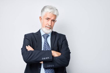 Stüdyonun arka planında izole edilmiş ciddi yüzlü ve gri saçlı kendinden emin bir iş adamının portresi. 60 yaşında yakışıklı bir adam, Sui 'de patron.