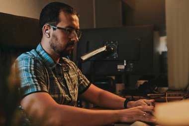 Çeşitli ofislerde bilgisayar üzerinde çalışan profesyonel bir programcı portresi. Modern bilişim teknolojileri, yapay zekanın geliştirilmesi, programlar, uygulamalar ve video oyunları konsepti