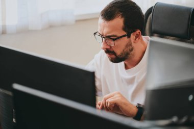 Çeşitli ofislerde bilgisayar üzerinde çalışan profesyonel bir programcı portresi. Modern bilişim teknolojileri, yapay zekanın geliştirilmesi, programlar, uygulamalar ve video oyunları konsepti