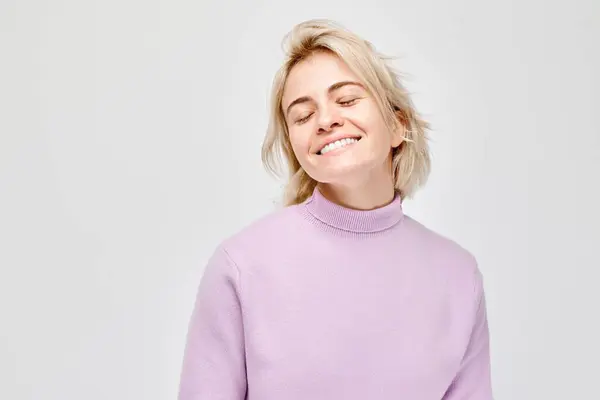 白种人年轻的金发女人在白色的工作室背景上快乐地微笑着 快乐的女孩 穿着淡紫色毛衣 满脸喜色 — 图库照片