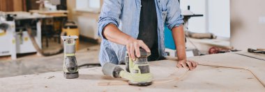 Marangoz marangozluk atölyesinde ahşapla çalışır. Adam profesyonel olarak ahşap işi yapıyor.