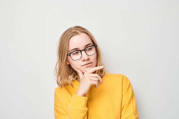 Έξυπνη Ξανθιά Μαθήτρια Γυαλιά Που Αγγίζει Πηγούνι Επιλέγει Απομονωμένη Λευκό — Φωτογραφία Αρχείου