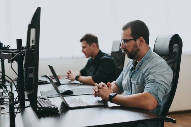 Çeşitli ofislerde bilgisayar üzerinde çalışan iki profesyonel erkek programcının portresi. Modern bilişim teknolojileri, yapay zekanın geliştirilmesi, programlar, uygulamalar ve video oyunları konsepti