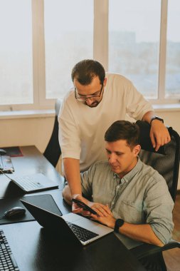 Çeşitli ofislerde bilgisayar üzerinde çalışan iki profesyonel erkek programcının portresi. Modern bilişim teknolojileri, yapay zekanın geliştirilmesi, programlar, uygulamalar ve video oyunları konsepti