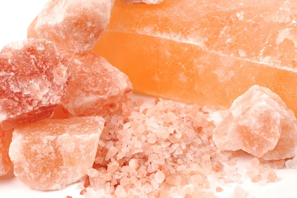 Chipped Himalayan salt stone, crystals and crushed blocks of natural pink salt close up background