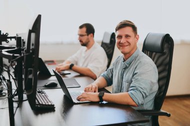 Çeşitli ofislerde bilgisayar üzerinde çalışan iki profesyonel erkek programcının portresi. Modern bilişim teknolojileri, yapay zekanın geliştirilmesi, programlar, uygulamalar ve video oyunları konsepti