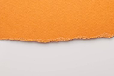 Yırtık kenarlı kağıt parçalarından sanat kolajı. Yapışkan notlar turuncu beyaz renkler topluyor, defter sayfalarının parçalarını. Soyut arka gruplandırma