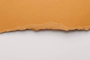 Yırtık kenarlı kağıt parçalarından sanat kolajı. Yapışkan notlar kahverengi beyaz renkler, defter sayfalarının parçalarını topluyor. Soyut arka gruplandırma