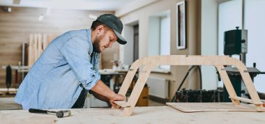 Marangoz marangozluk atölyesinde ahşapla çalışır. Adam profesyonel olarak ahşap işi yapıyor.