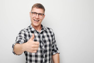 Beyaz stüdyo arka planında izole edilmiş, sevinçle gülümseyen genç beyaz adamın portresi. Doğru seçimi, doğru kararı onaylar