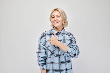 Beyaz stüdyo arka planında izole edilmiş, neşeli bir şekilde gülümseyen sarışın genç bir kadının portresi. İyi bir seçim, doğru bir karar.