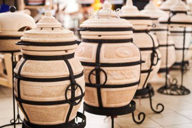 Düz ekmek, ızgara ve barbekü yapmak için geleneksel tandoor kil fırını. Mağaza penceresinde yeni mutfak aletleri