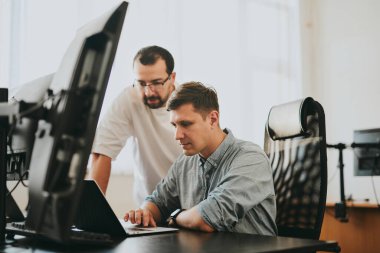 Çeşitli ofislerde bilgisayar üzerinde çalışan iki profesyonel erkek programcının portresi. Modern bilişim teknolojileri, yapay zekanın geliştirilmesi, programlar, uygulamalar ve video oyunları konsepti