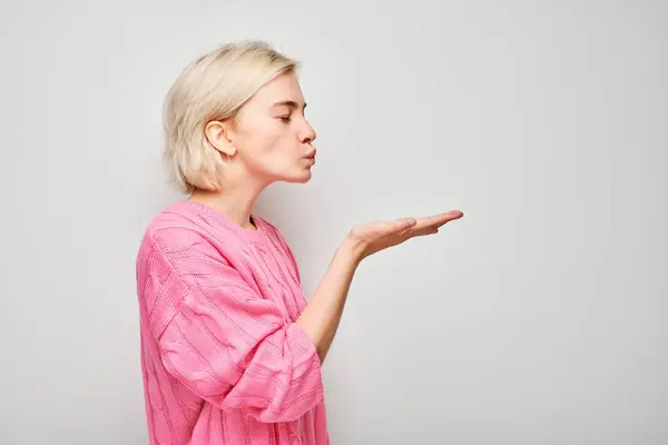 Retrato Una Joven Rubia Suéter Rosa Enviando Beso Aire Sosteniendo —  Fotos de Stock
