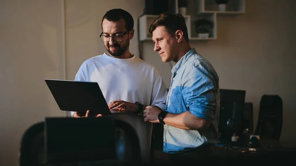 Portrait of two professional male programmers working on computer in diverse offices. Modern IT technologies, development of artificial intelligence, programs, applications and video games concept