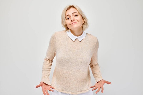 Портрет студентки с пустыми карманами, изолированными на белом фоне студии. Финансовый кризис, отсутствие концепции денег