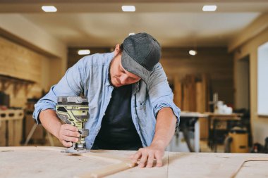 Marangoz marangozluk atölyesinde ahşapla çalışır. Adam profesyonel olarak ahşap işi yapıyor.