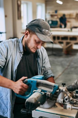 Marangoz marangozluk atölyesinde ahşapla çalışır. Adam profesyonel olarak ahşap işi yapıyor.