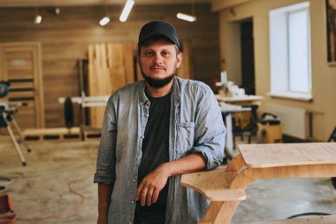 Marangoz marangozluk atölyesinde ahşapla çalışır. Adam profesyonel olarak ahşap işi yapıyor.